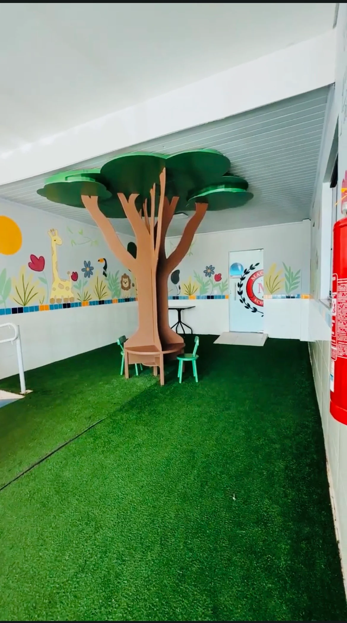 Espaço de leitura com árvore cenográfica na Mackedu School